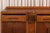 An oak sideboard with the stepped, rounded outlines of the Art Deco period. Two drawers with carved handles sit above two...