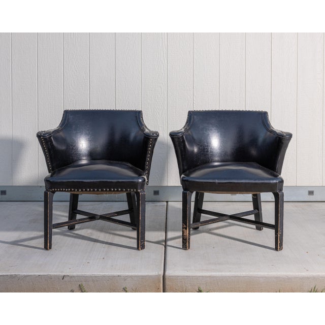 Pair of vintage barrel-back club armchairs featuring sculptural wraparound backs, flared arms, decorative metal nailhead...