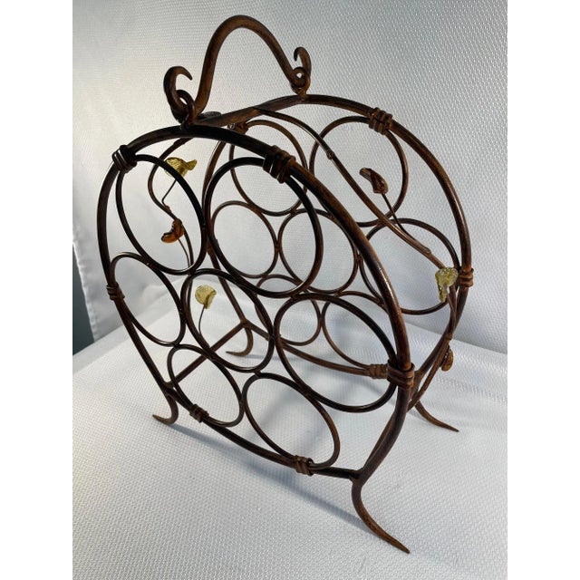 A stunning Mediterranean Style Wrought Iron Wine Rack Holder with vining glass leaves in amber and gold. Circa Late 20th...