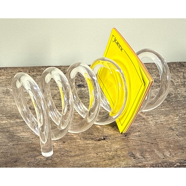 This lucite desk accessory features a continuous spiral coil design that functions as a letter or mail holder. The clear...