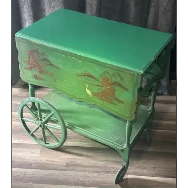 This antique Paalman Furniture green drophandle tea wagon with an Asian scene painted on the drop leafs made in Grand...