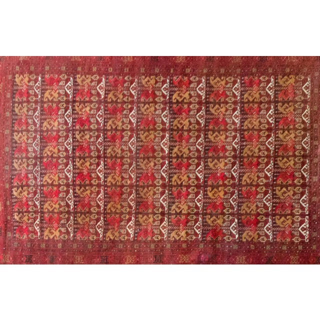 This vintage late-20th-century Afghani Bashir rug is a showstopper, hand-knotted with rich wool in deep crimson, golden...