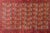 This vintage late-20th-century Afghani Bashir rug is a showstopper, hand-knotted with rich wool in deep crimson, golden...