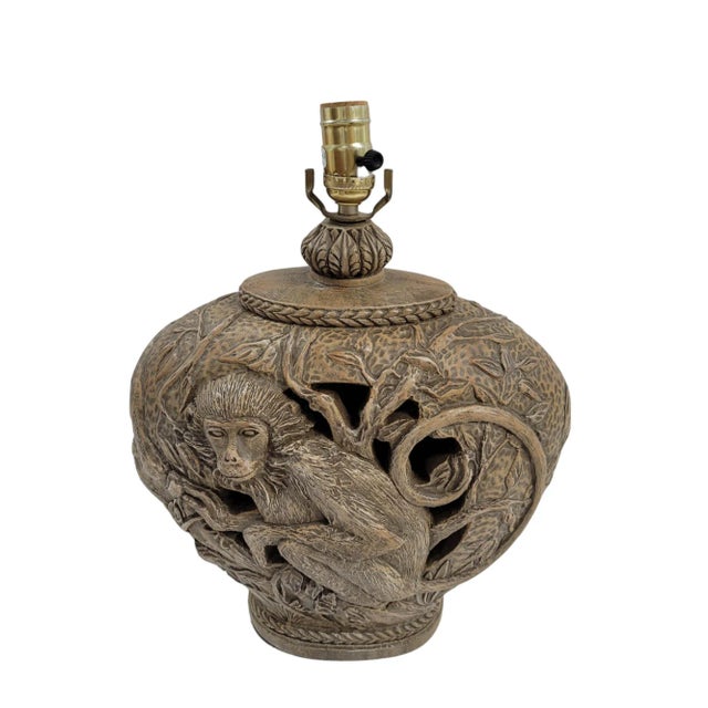 A Hollywood Regency table lamp featuring a captivating monkey sculpture. The perforated design adds a layer of complexity...