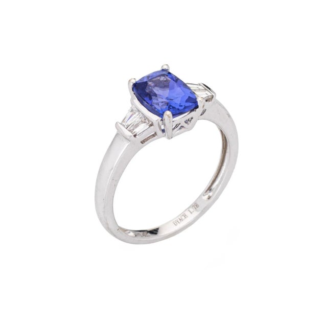 Stylish estate tanzanite & diamond ring crafted in 14 karat white gold. Cushion cut tanzanite measures 8mm x 6mm (1.78...