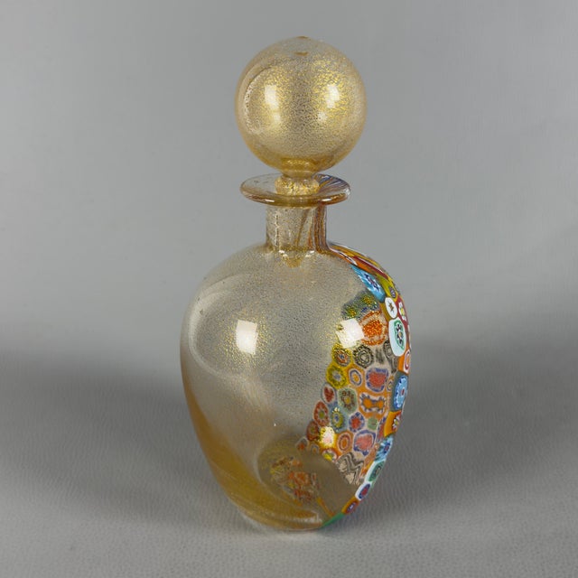 Highly prized decorative Murano glass bottle with submerged gold leaf and polychrome murrine. Subject and Style: Refined...