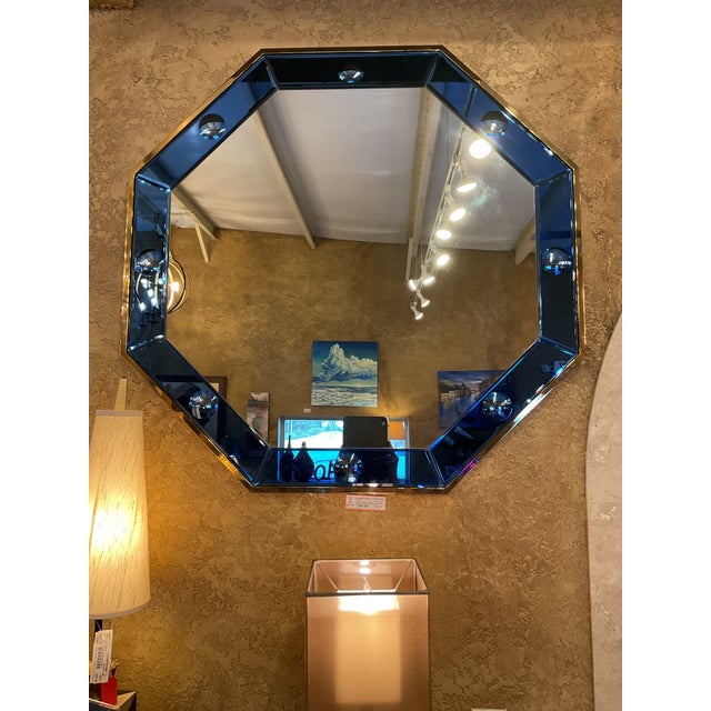 The blue octagonal wall mirror is designed by Bunny Williams. It measures 38" x 38". This unique mirror features a non-...