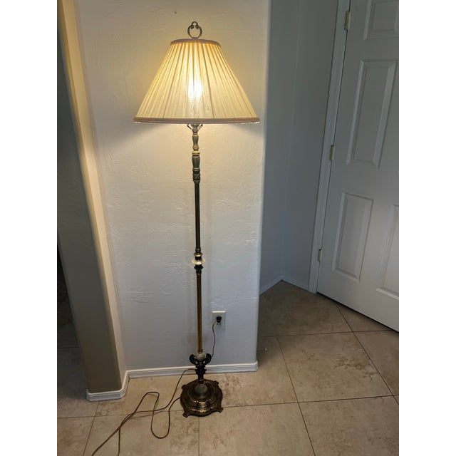 This antique-style brass floor lamp features onyx accents on the central column and a decorative cast metal base with...