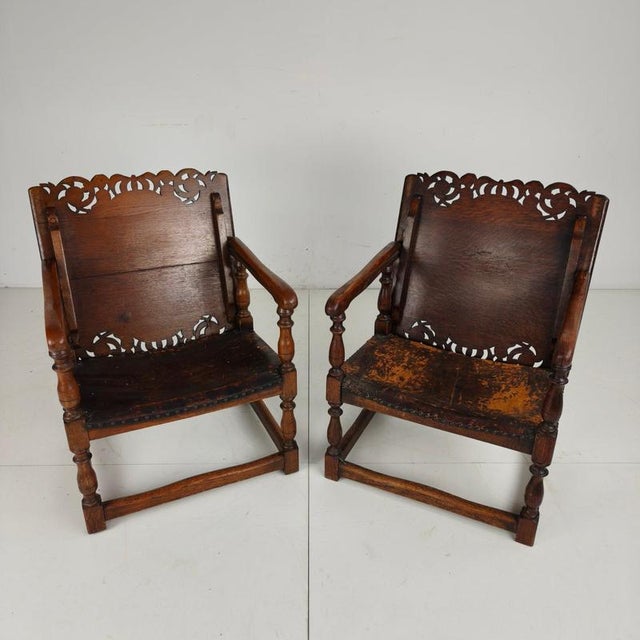Beautiful pair of English antique Jacobean-style monk armchairs that convert into side tables, stamped and made by F....