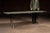 Long, narrow trestle table constructed from solid oak planks set atop a pair of cast iron folding-style bases with...