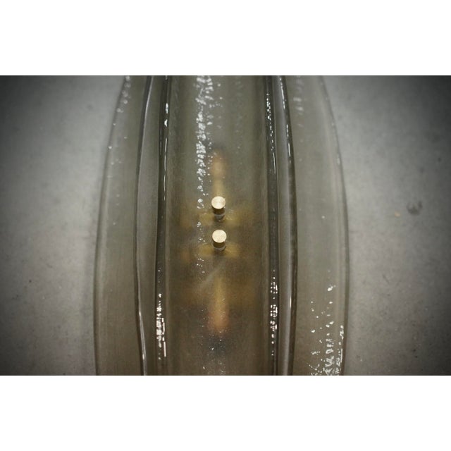 Very original Murano glass wall lamp with a very elongated design of the glass half shell and a unique smoked color. The...