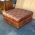 This is a late 1990s Hancock and Moore tufted leather Chesterfield style square ottoman. It is a nice patinated whiskey...