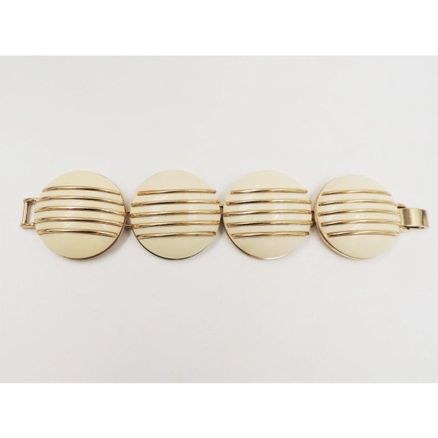 1950s goldtone and ivory colored resin bracelet with fold over clasp. Marked "Monet." Measures: 7.5 inches long by 1.63...