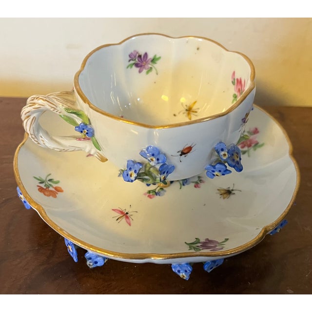 Antique Meissen porcelain tea cup and saucer decorated with applied forget-me-not flowers and hand painted insects....