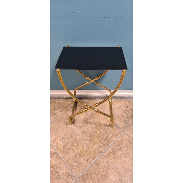 Brass table with Italian black production shelf of the 80s of the 1980s. Particular cross support. In excellent condition,...