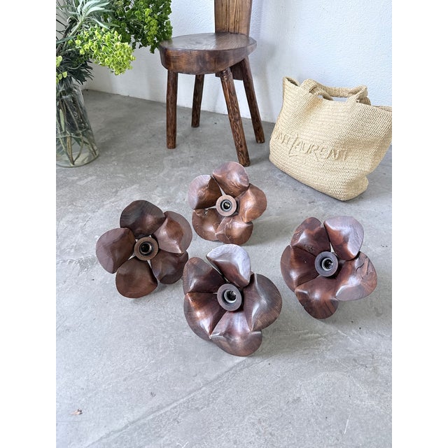 A vintage set of four wall sconces from the 1970s, entirely handcrafted from carved wood in the shape of flowers. these...