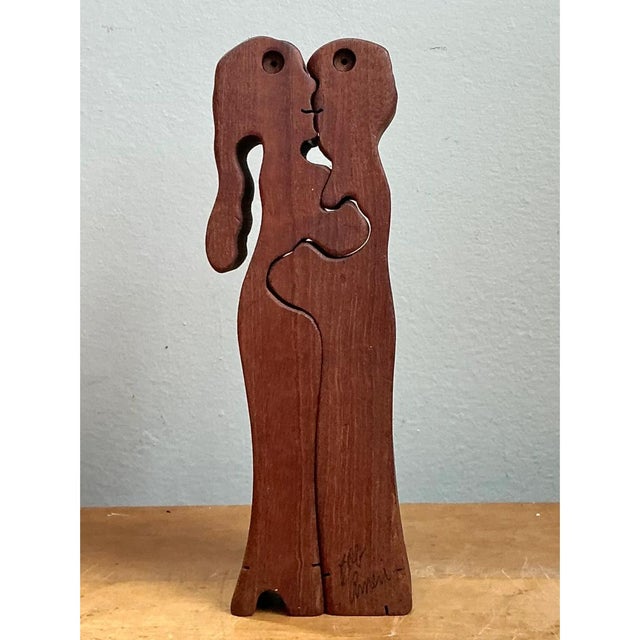 This vintage sculpture distills a pair of lovers into a single flowing, minimalist form, cut from a warm, reddish-brown...