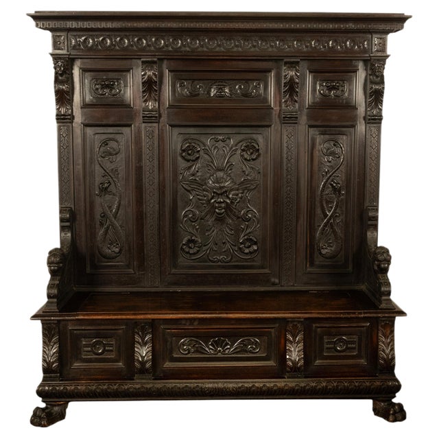 A fine antique Italian Renaissance Revival carved ebonized walnut high-back bench, settle, circa 1880. The settle's high-...
