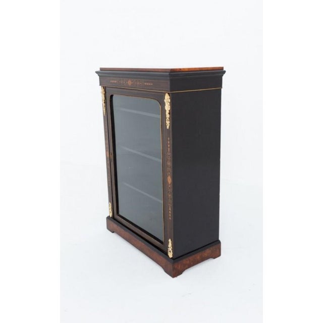 Victorian ebonised pier cabinet This pretty pier cabinet features a central glazed door flanked by marquetry panels to...
