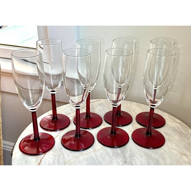 Set of 8 champagne glasses with red stems. Crafted from high-quality glass, these contemporary champagne flutes stand at...