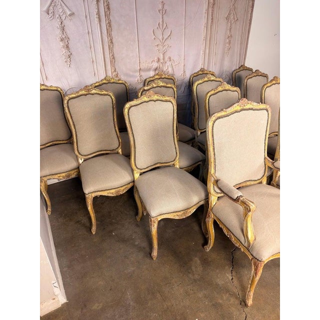 An exceptional set of fourteen French Louis XV style dining chairs, including twelve side chairs and two armchairs,...