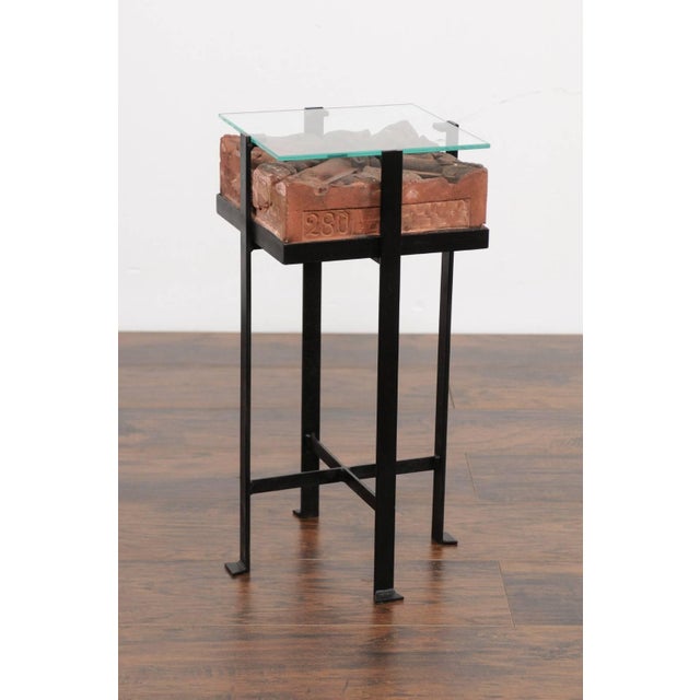 A contemporary side table made of an Italian antique red brick from the early 20th century with glass top and custom iron...