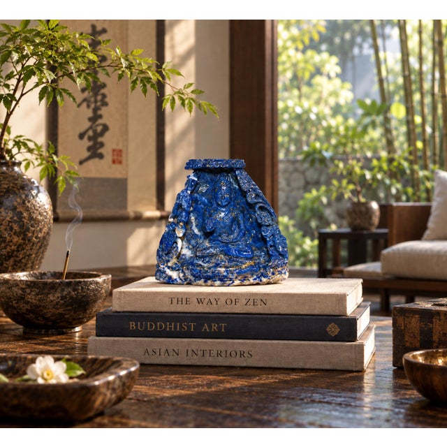 A finely hand-carved sculpture in natural fine grades lapis lazuli depicting the Buddha seated within an ornate alcove...