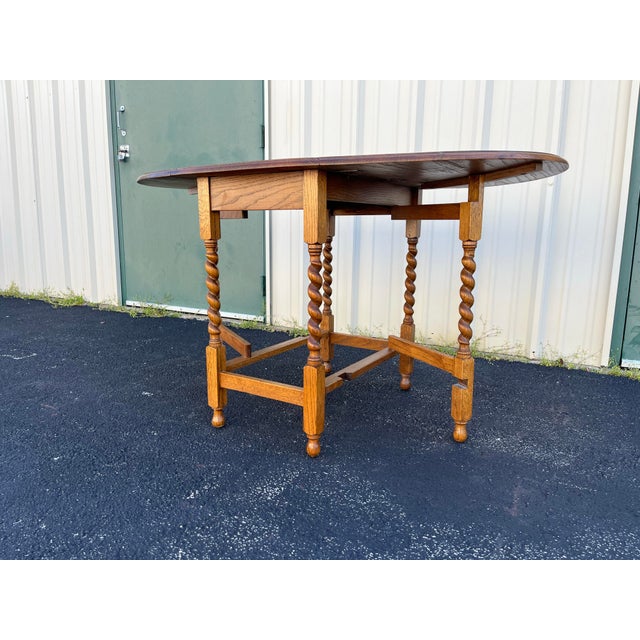 A stunning English oak gate leg table from the early 1900’s. Barley twist designs in each leg make this table stand apart...