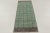Hand-knotted in wool, this vintage Turkish 2x7 runner rug from circa 1950–1960 features a mint green geometric field with...