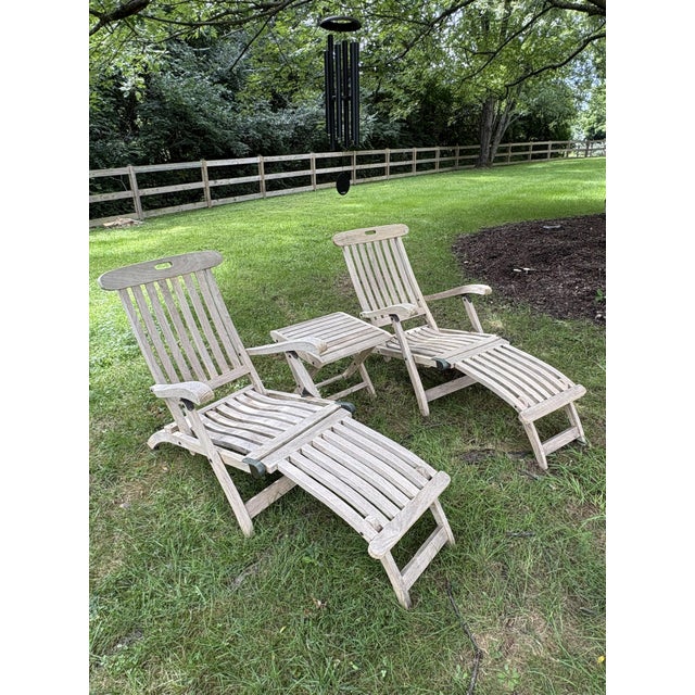A beautifully preserved pair of solid teak steamer chairs, likely British in origin and dating to the 1920s–1940s. Crafted...