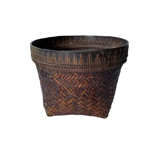 This mid-20th century hand-woven basket originates from the Dayak tribe of Borneo crafted with rattan fibres and an iron...