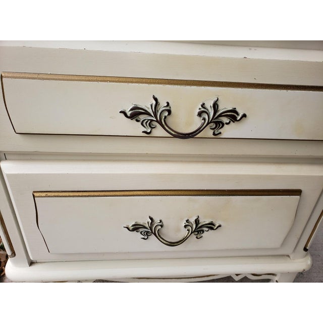 Beautiful 1970s ivory nightstand with gold accents/details and cast metal drawer pulls Two nice size drawers that are in...