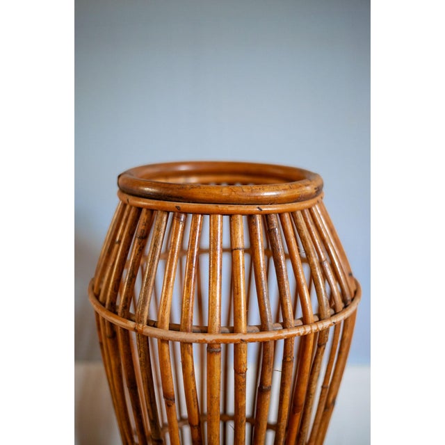 Slightly tapered bamboo structure in a natural finish with vertical reed-like elements, with a rhythm punctuated by...