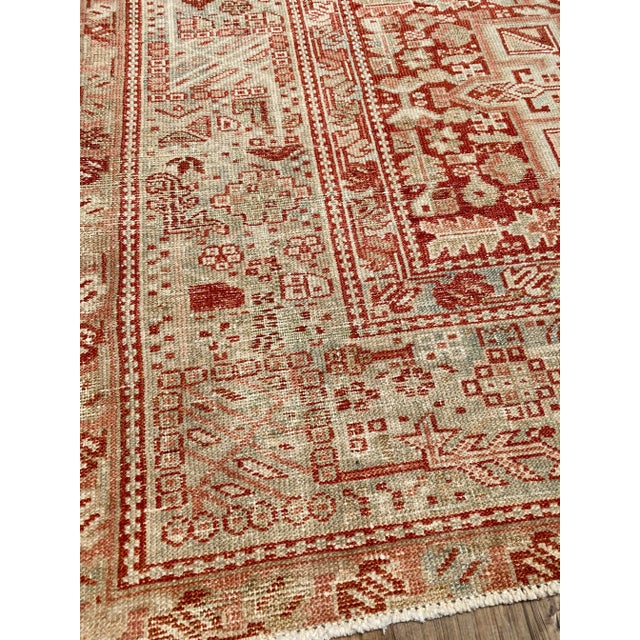 A lovely antique Heriz rug. This antique Heriz offers a traditional red palette with muted blue accents.
