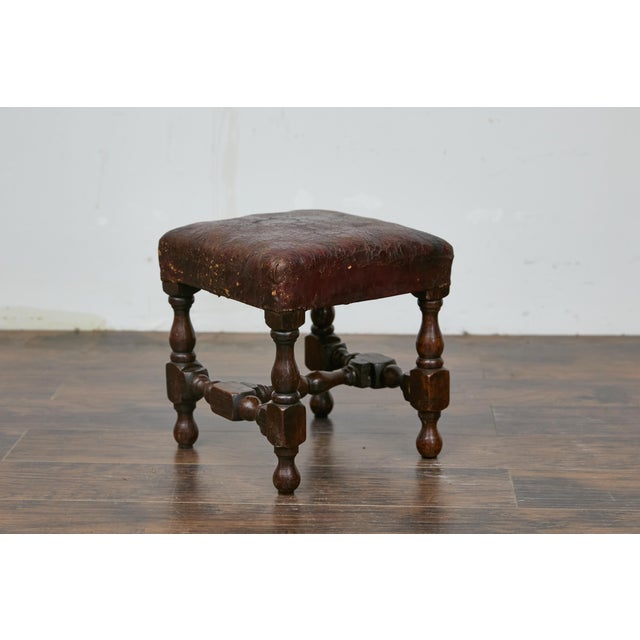 An English oak footstool from the 19th century with leather seat and turned legs. This English oak stool from the 19th...