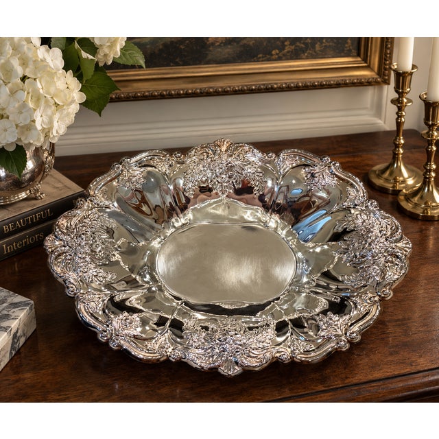 A generously scaled vintage silverplate centerpiece bowl by Oneida, richly decorated with raised floral bouquets, foliage...