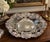 A generously scaled vintage silverplate centerpiece bowl by Oneida, richly decorated with raised floral bouquets, foliage...