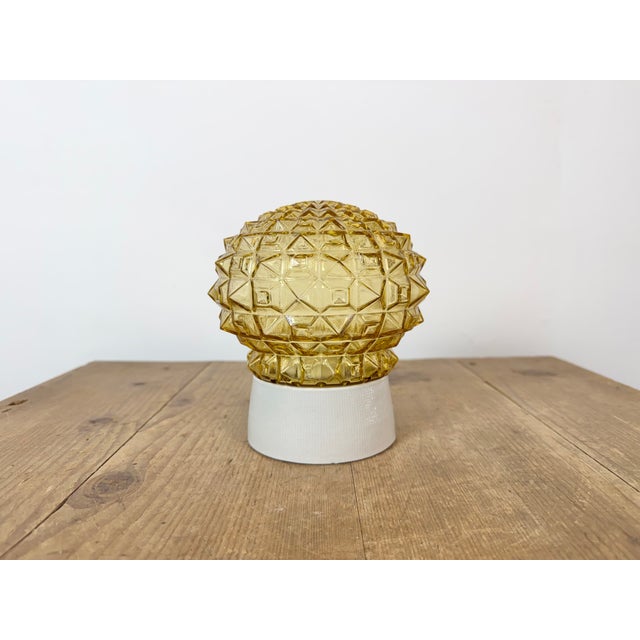 Vintage industrial ceiling or wall light made in former Czechoslivakia during the 1970s. It features a white porcelain...