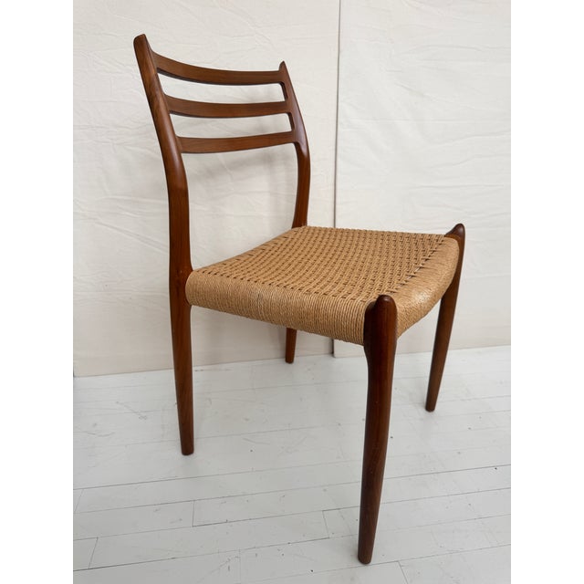 This iconic Model 78 dining chair, designed by Niels Otto Møller and produced by JL Møllers Møbelfabrik, blends Danish...