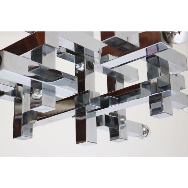 lluminate your space with the timeless elegance of this vintage chrome chandelier Model: Metric, designed by the legendary...