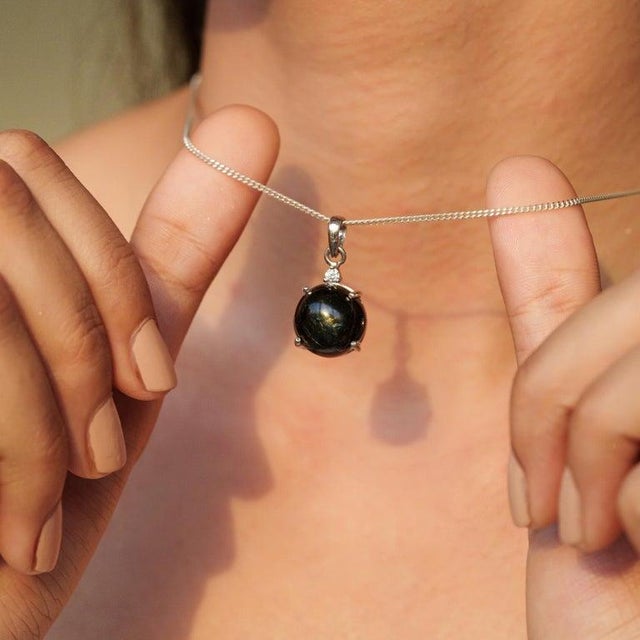 This black Star Drop Pendant is finely crafted in 925 Sterling Silver. Featuring a captivating 5.71 carat round Black Star...