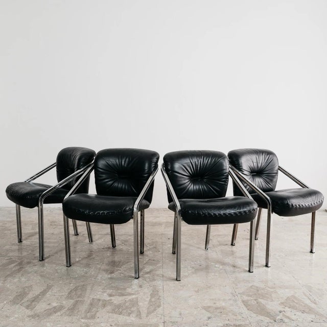 Elegant dining set by Mobil Girgi, consisting of four armchairs with a chromed steel frame and black leather upholstery....