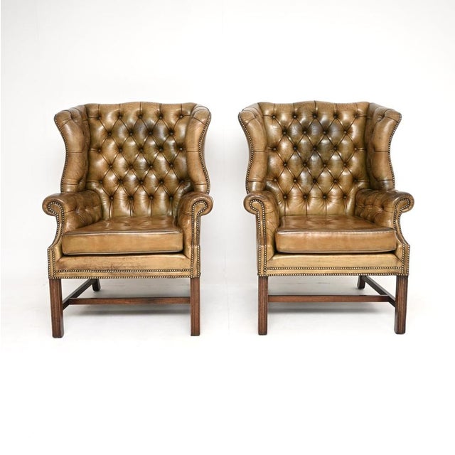 A very impressive and extremely high quality pair of antique Georgian style leather wing back armchairs. They were made in...