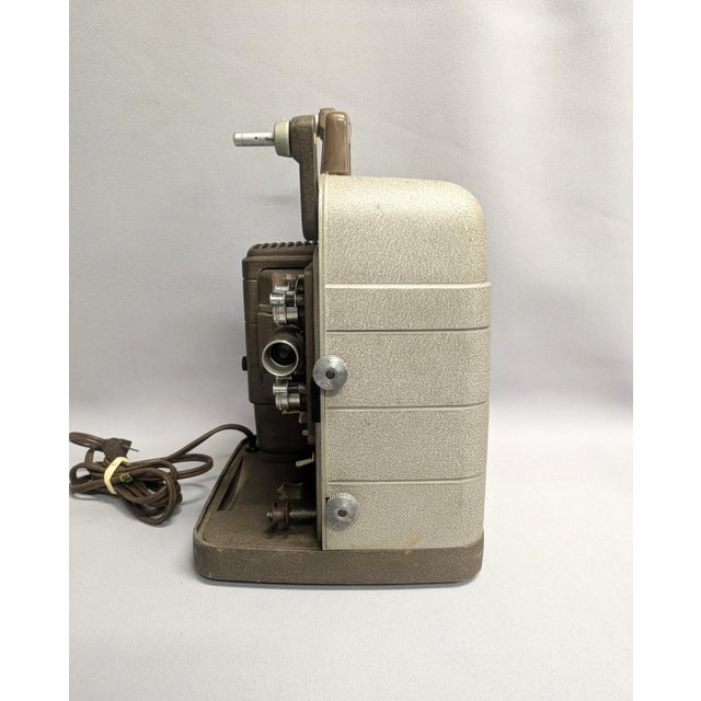 A 1950s Bell & Howell movie projector. The super 8mm film projector is a model #253 AX. The projector features a metal...