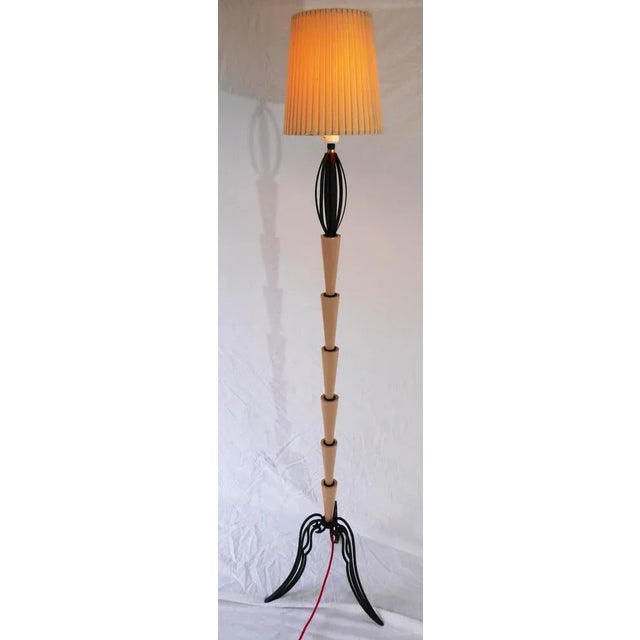 Vintage floor lamp on wrought iron base. Body in turned wood elements. Switch switch. Red fabric wire. The electric part...
