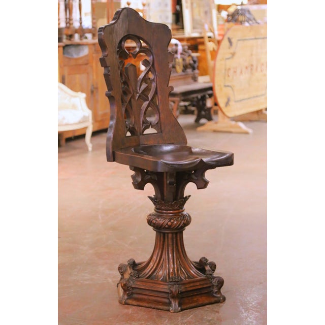 Crafted in France circa 1870, this striking antique oak chair reflects the Gothic Revival style through its architectural...