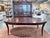 A sophisticated Ethan Allen Hathaway dining table showcasing rich zebrawood veneer paired with Indonesian mahogany solids...