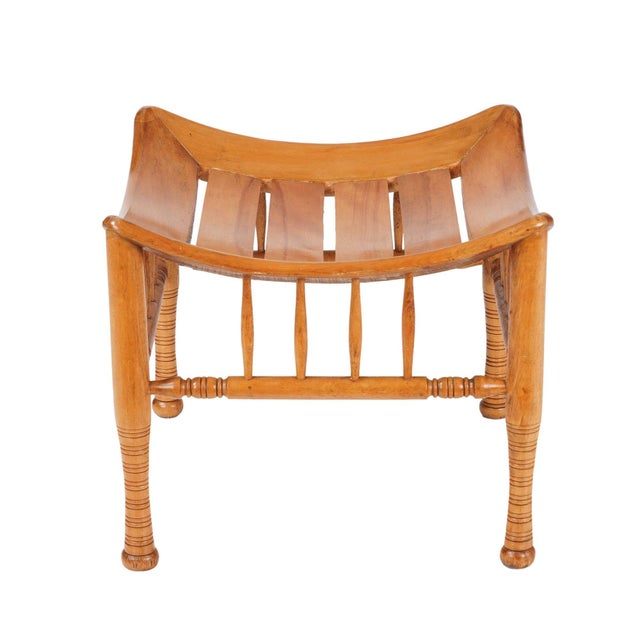 Egyptian Revival Thebes style stool in naturally finished beechwood, after an archeological model. The four turned legs...