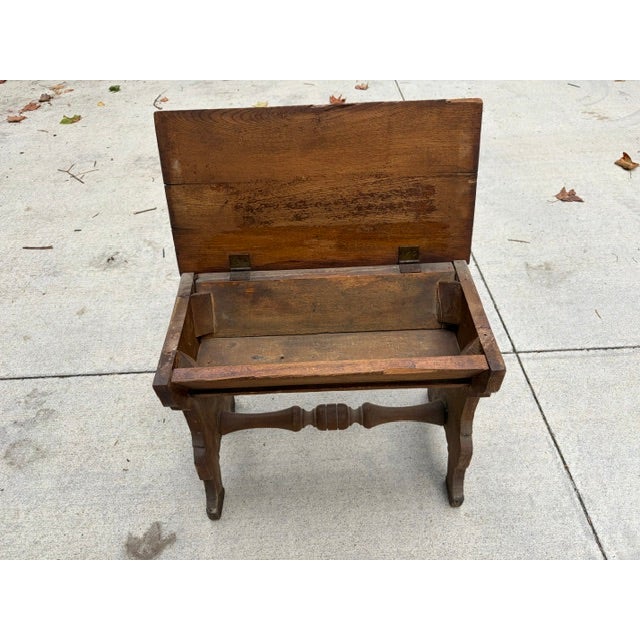 This "slipper bench" from the 1950’s has storage under the seat for slippers. The bench is solid wood with carvings on...