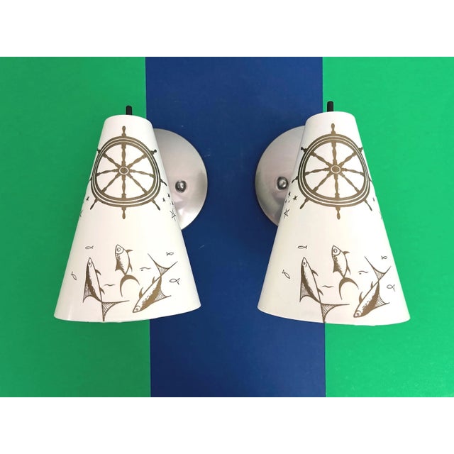 Fresh and fun pair of 1960s coastal style wall sconces of molded creamy white resin painted with central matte gold ships...